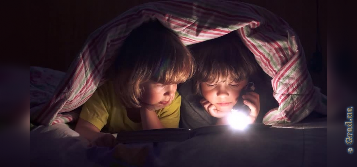 Дети читают с фонариком